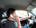 Mann mit Handy am Steuer
